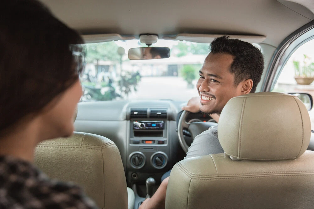 asian male taxi driver welcoming his customer