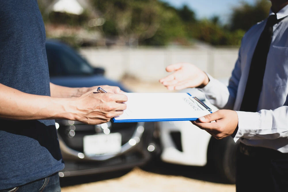 Customers and car insurance agents have entered into agreements and signed documents to claim compensation after a car crash, Insurance concept.